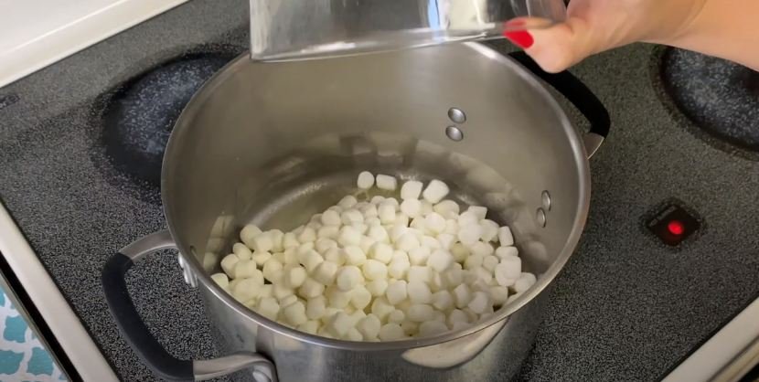 adding marshmallows into a pan